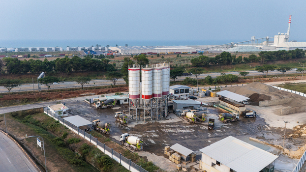 Aerial view of Kawasan Industri Terpadu Batang featuring a concrete batching plant with silos and cement mixer trucks in Kecamatan Gringsing Jawa Tengah Indonesia.
