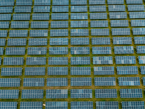 Aerial view of a large solar farm with rows of photovoltaic panels arranged in a grid pattern across the landscape in Ogun State Nigeria.
