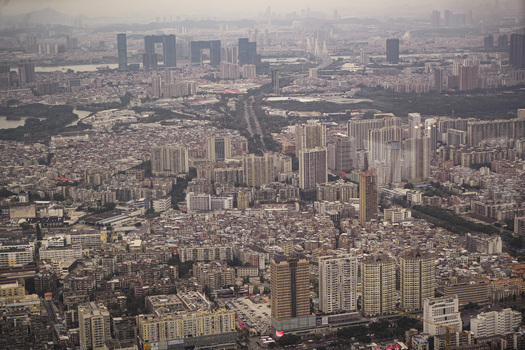 Aerial view of the dense urban landscape of Guangzhou featuring modern high rise skyscrapers and traditional residential buildings in Guangzhou Guangdong Province China. Aerial view of the dense urban landscape of Guangzhou featuring modern high rise skyscrapers and traditional residential buildings in Guangzhou Guangdong Province China.