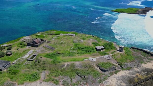 Aerial view of coastal fort ruins on a grassy headland Mauritius.