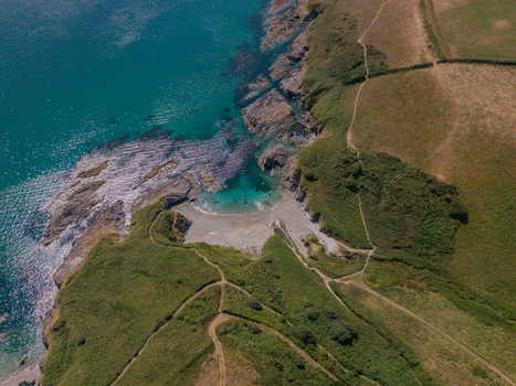 Aerial view of Lansallos beach featuring rugged cliffs turquoise sea and green coastal paths in Lansallos England United Kingdom. Aerial view of Lansallos beach featuring rugged cliffs turquoise sea and green coastal paths in Lansallos England United Kingdom.