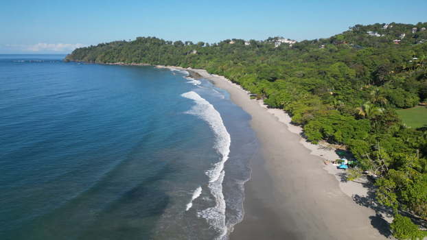 Aerial view of the coastline where the lush green forest meets the sandy beach and the turquoise ocean Quepos Puntarenas Province Costa Rica. Aerial view of the coastline where the lush green forest meets the sandy beach and the turquoise ocean Quepos Puntarenas Province Costa Rica.