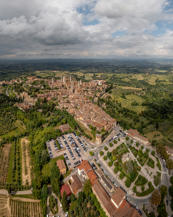 Aerial view of the historic town with its iconic medieval towers surrounded by lush green hills vineyards and olive groves in San Gimignano Tuscany Italy. Aerial view of the historic town with its iconic medieval towers surrounded by lush green hills vineyards and olive groves in San Gimignano Tuscany Italy.