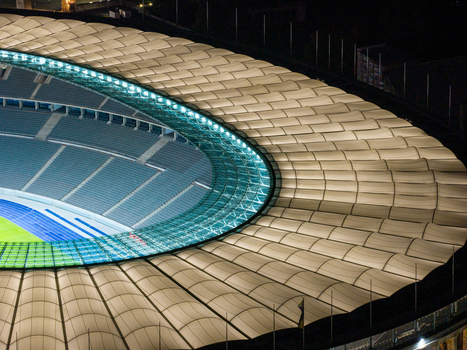 Berlin Germany 26 September 2026 Aerial view of the Olympiastadion Berlin at night highlighting its iconic illuminated roof structure and the empty stadium seating.