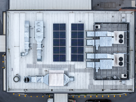 Aerial view of industrial roof featuring solar panels ventilation ducts and HVAC units in Melbourne VIC Australia.