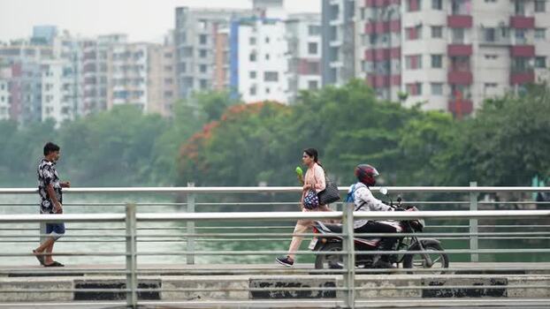 View of people and traffic on a bridge in Dhaka Bangladesh.