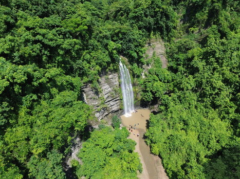 Aerial view of the waterfall in the lush green forest of Sitakund with people swimming in the pool at the base Sitakund Chittagong Division Bangladesh. Aerial view of the waterfall in the lush green forest of Sitakund with people swimming in the pool at the base Sitakund Chittagong Division Bangladesh.