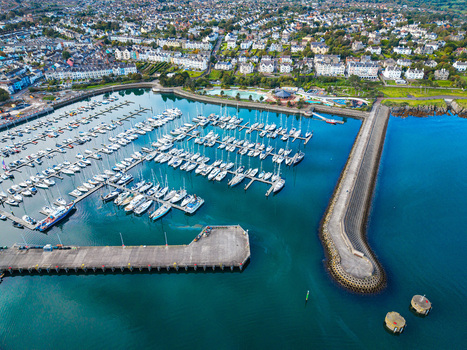 Aerial view of Bangor Harbour and Town with numerous boats docked in the marina a long stone breakwater and coastal town buildings in Bangor Northern Ireland United Kingdom.
