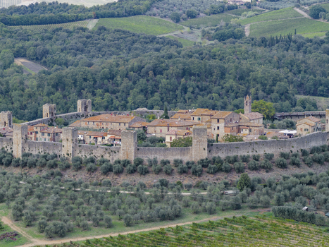 Aerial view of the historic walled town of Monteriggioni featuring medieval stone fortifications terracotta roofed houses and surrounding olive groves Monteriggioni Tuscany Italy.