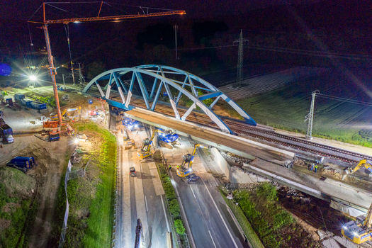 Forchheim Germany 18 May 2024 Aerial view of the A73 bridge construction site at night with a blue arched structure heavy machinery and bright floodlights. Forchheim Germany 18 May 2024 Aerial view of the A73 bridge construction site at night with a blue arched structure heavy machinery and bright floodlights.