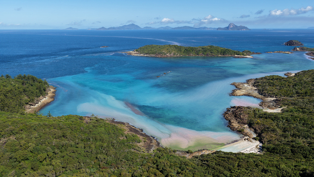 Aerial view of Chance Bay with turquoise waters rocky coastline and lush green vegetation in Whitsundays Queensland Australia. Aerial view of Chance Bay with turquoise waters rocky coastline and lush green vegetation in Whitsundays Queensland Australia.