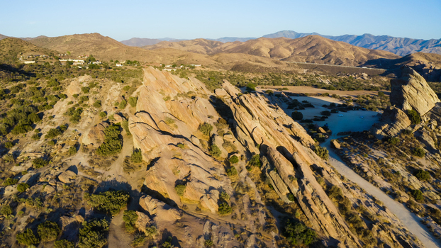 Aerial view of the dramatic rock formations at Vasquez Rocks Natural Area Park with rugged terrain and desert vegetation in the United States. Aerial view of the dramatic rock formations at Vasquez Rocks Natural Area Park with rugged terrain and desert vegetation in the United States.