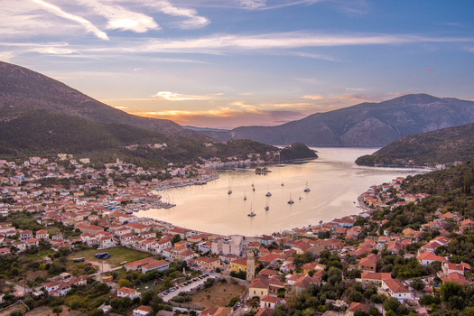 Aerial view of Vathy the main port of Ithaca with its traditional houses boats anchored in the bay and surrounding hills at sunset in Ithaki Greece.