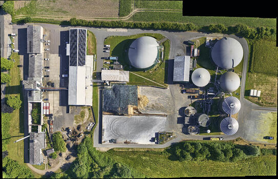 Schleswig Germany 26 June 2026 Aerial view of biogas works on an industrial site with large fermentation tanks storage silos and solar panels on warehouse rooftops. Schleswig Germany 26 June 2026 Aerial view of biogas works on an industrial site with large fermentation tanks storage silos and solar panels on warehouse rooftops.