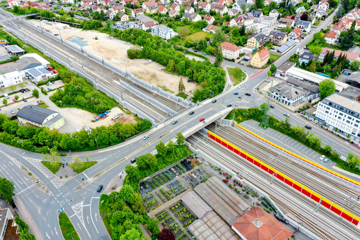 Aerial view of the Bahnhofstrasse bridge crossing over railway tracks with red and yellow noise barriers surrounded by houses and trees in Forchheim Bayern Germany. Aerial view of the Bahnhofstrasse bridge crossing over railway tracks with red and yellow noise barriers surrounded by houses and trees in Forchheim Bayern Germany.