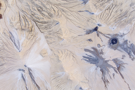 Aerial view of the mud volcanoes at Vulcanii Noroiosi Paclele Mari with intricate patterns of dried mud flows and active craters in Paclele Buzau County Romania.