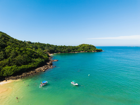 Aerial view of Jungle Beach with lush green hills turquoise water and small boats anchored near the shore in Unawatuna Sri Lanka. Aerial view of Jungle Beach with lush green hills turquoise water and small boats anchored near the shore in Unawatuna Sri Lanka.