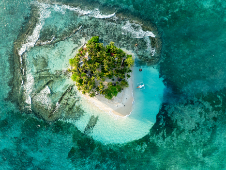 Aerial view of Naked Island a small tropical island with lush palm trees and white sand beaches surrounded by vibrant turquoise coral reefs in Siargao Philippines. Aerial view of Naked Island a small tropical island with lush palm trees and white sand beaches surrounded by vibrant turquoise coral reefs in Siargao Philippines.