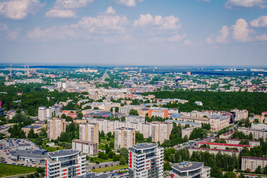 Riga Latvia 25 May 2014 Aerial view of modern residential district Skanste and Riga city skyline with apartment buildings green trees and urban infrastructure under a blue sky.