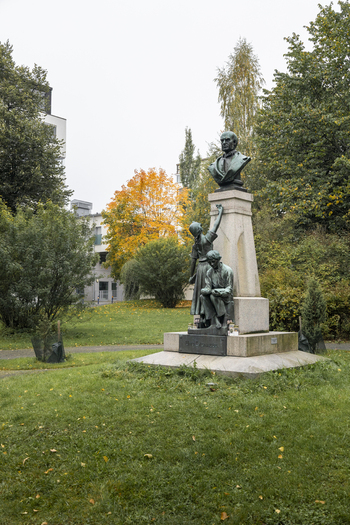 View of the Minna Canth statue surrounded by autumn trees and green grass in a park in Jyvaskyla Central Finland Finland.