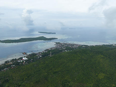 Aerial view of the coastline meeting the lush greenery houses nestled along the shore and islands dotting the horizon Karimunjawa Central Java Indonesia.