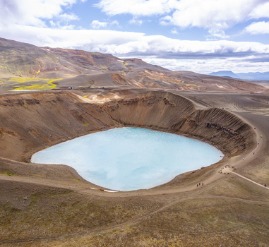 Aerial view of Viti crater lake with its turquoise water surrounded by volcanic landscape and rugged terrain in Thingeyjarsveit Iceland.