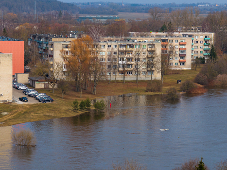 Kedainiai Lithuania 17 March 2026 Aerial view of apartment buildings and a parking lot situated next to a flooded river with bare trees under a hazy sky. Kedainiai Lithuania 17 March 2026 Aerial view of apartment buildings and a parking lot situated next to a flooded river with bare trees under a hazy sky.