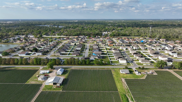 Aerial view of a residential neighborhood bordering large agricultural fields in Plant City Florida United States. Aerial view of a residential neighborhood bordering large agricultural fields in Plant City Florida United States.