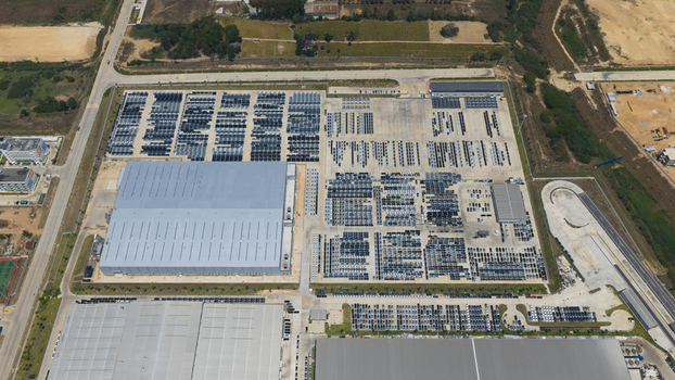 Aerial view of the BYD Thailand Rayong Office Building and large industrial factory complex with rows of parked vehicles and surrounding fields Phananikhom Rayong Thailand. Aerial view of the BYD Thailand Rayong Office Building and large industrial factory complex with rows of parked vehicles and surrounding fields Phananikhom Rayong Thailand.