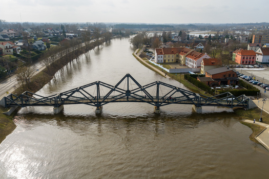 Kedainiai Lithuania 17 March 2026 Aerial view of the modern steel pedestrian bridge over the Nevezis River with people walking across surrounded by historic buildings. Kedainiai Lithuania 17 March 2026 Aerial view of the modern steel pedestrian bridge over the Nevezis River with people walking across surrounded by historic buildings.
