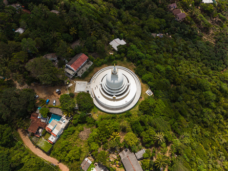 Aerial view of the Japanese Peace Pagoda Rumassala surrounded by dense tropical forest and lush greenery on a hillside in Unawatuna Southern Province Sri Lanka. Aerial view of the Japanese Peace Pagoda Rumassala surrounded by dense tropical forest and lush greenery on a hillside in Unawatuna Southern Province Sri Lanka.
