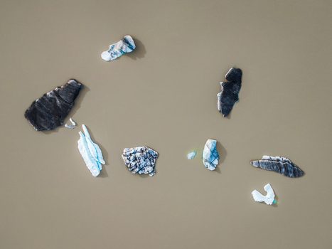 Aerial view of scattered icebergs and glacier fragments floating in the murky glacial water of Iceland. Aerial view of scattered icebergs and glacier fragments floating in the murky glacial water of Iceland.