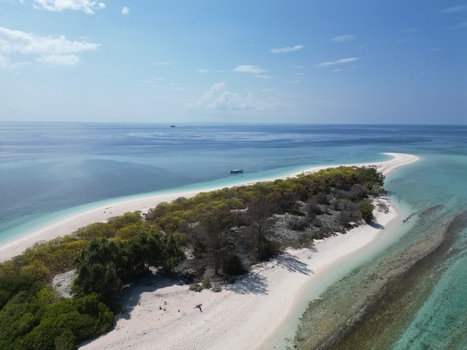 Aerial view of Pulau Ndaa with its white sand beach lush vegetation and surrounding turquoise waters in Tomia South East Sulawesi Indonesia.