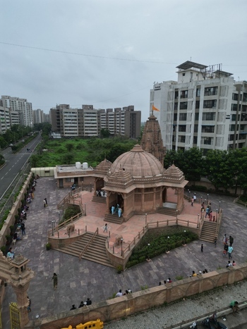 Aerial view of the Siddhivinayak Mandir Virar West temple with traditional stone architecture and a courtyard surrounded by urban residential buildings in Vasai Virar Maharashtra India.