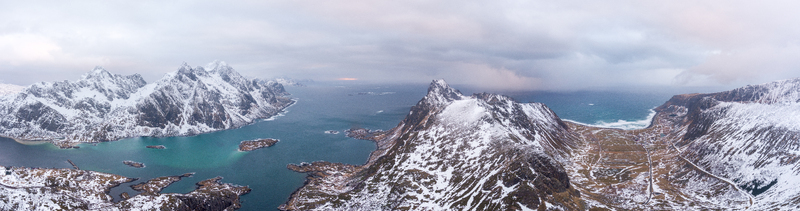 Aerial view of Lofoten with snow covered mountains deep blue sea and rocky coastline in Nordland Norway.