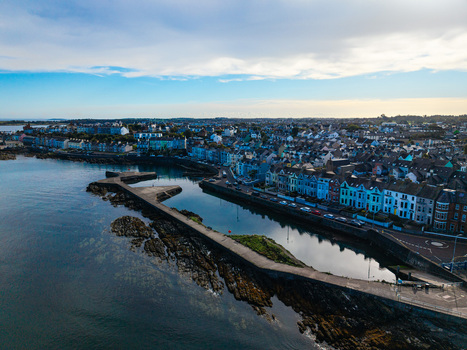 Aerial view of Bangor Harbour and Town featuring colorful waterfront buildings and a stone pier extending into the sea in Bangor Northern Ireland United Kingdom.
