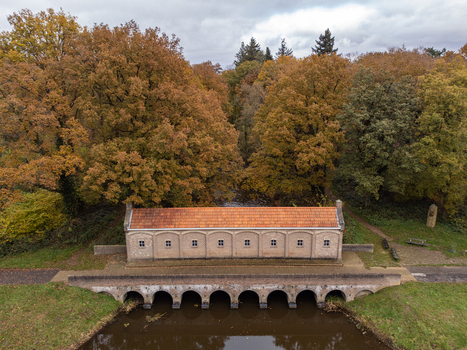 Aerial view of a quaint brick structure nestled under autumnal trees reflected in the dark waters of the canal Schuivenhuisje Overijssel Netherlands. Aerial view of a quaint brick structure nestled under autumnal trees reflected in the dark waters of the canal Schuivenhuisje Overijssel Netherlands.