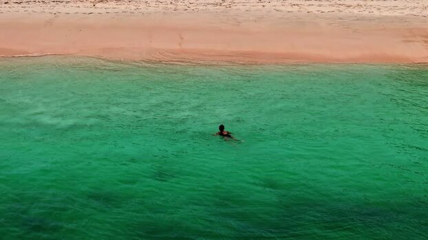 Aerial view of a swimmer in turquoise waters in Bali Indonesia.