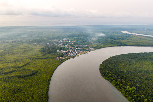 Aerial view of Opobo Town nestled along the winding river surrounded by dense mangrove forests in the Niger Delta region Opobo Town Rivers Nigeria. Aerial view of Opobo Town nestled along the winding river surrounded by dense mangrove forests in the Niger Delta region Opobo Town Rivers Nigeria.