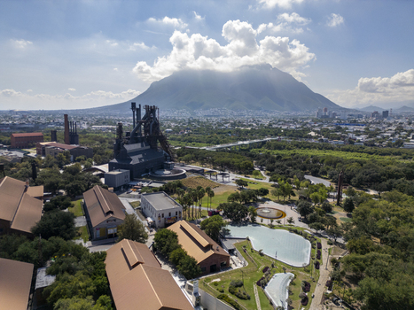 Aerial view of Fundidora Park with historic industrial architecture green spaces and water features against the Cerro de la Silla mountain in Monterrey Nuevo Leon Mexico. Aerial view of Fundidora Park with historic industrial architecture green spaces and water features against the Cerro de la Silla mountain in Monterrey Nuevo Leon Mexico.