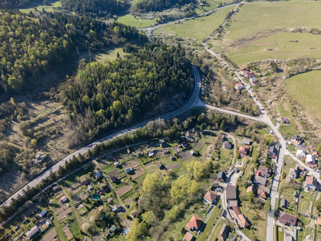 Aerial view of the historic village nestled among lush green hills dense forests and rolling fields under bright sunlight in Valaska Dubova Zilina Region Slovakia. Aerial view of the historic village nestled among lush green hills dense forests and rolling fields under bright sunlight in Valaska Dubova Zilina Region Slovakia.