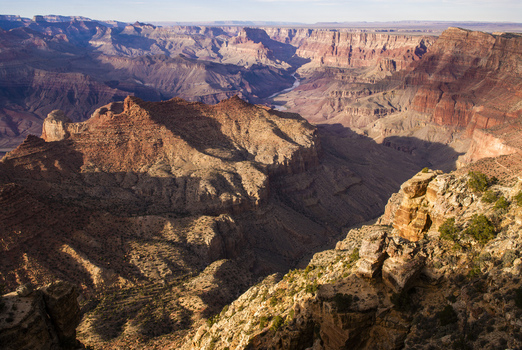 View of the Grand Canyon with deep rocky gorges and layered geological formations illuminated by golden hour light in Coconino County Arizona United States. View of the Grand Canyon with deep rocky gorges and layered geological formations illuminated by golden hour light in Coconino County Arizona United States.