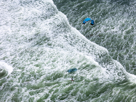 Aerial view of a kitesurfer gliding over the turbulent waves of the Indian Ocean at Depok Beach Special Region of Yogyakarta Indonesia.