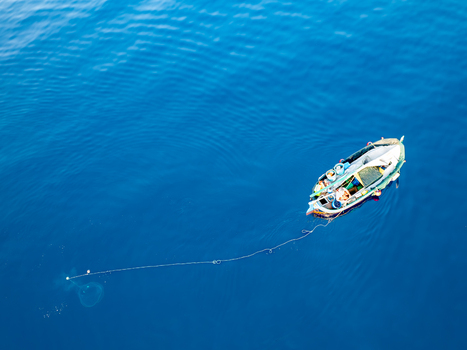 Aerial view of a small fishing boat floating on the turquoise waters Ghajnsielem Gozo Malta. Aerial view of a small fishing boat floating on the turquoise waters Ghajnsielem Gozo Malta.
