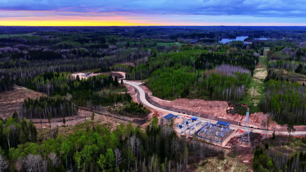 Aerial view of an electrical substation nestled within a dense forest landscape at sunset in Latvija. Aerial view of an electrical substation nestled within a dense forest landscape at sunset in Latvija.