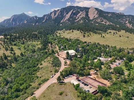 Aerial view of Chautauqua Park with its historic buildings tennis courts and parking area nestled against the iconic Flatirons rock formations in Boulder Colorado United States. Aerial view of Chautauqua Park with its historic buildings tennis courts and parking area nestled against the iconic Flatirons rock formations in Boulder Colorado United States.