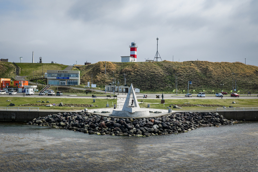 Aerial view of Cape Soya featuring the iconic triangular monument the red and white lighthouse and the rocky coastline in Wakkanai Hokkaido Japan. Aerial view of Cape Soya featuring the iconic triangular monument the red and white lighthouse and the rocky coastline in Wakkanai Hokkaido Japan.
