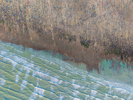 Aerial view of the Beach of the Bois de Cise with textured cliffs meeting the sea waves in Ault Hauts de France France.