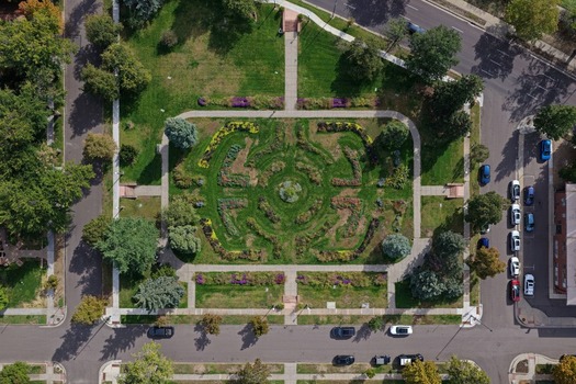 Aerial view of a symmetrical garden park with manicured flower beds green lawns and paved walkways surrounded by residential streets in Denver Colorado United States. Aerial view of a symmetrical garden park with manicured flower beds green lawns and paved walkways surrounded by residential streets in Denver Colorado United States.