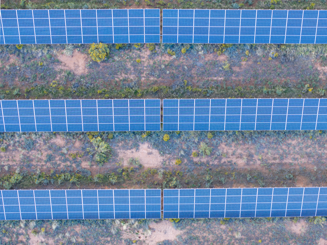 Aerial view of solar panels arranged in rows across a desert landscape with sparse shrubs and dry ground in Colorado United States. Aerial view of solar panels arranged in rows across a desert landscape with sparse shrubs and dry ground in Colorado United States.
